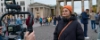 Une femme avec un bonnet orange est filmée devant la Porte de Brandebourg.