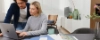 Un couple travaille ensemble sur un ordinateur portable dans un salon moderne avec Nolte Living.