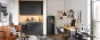 Cuisine moderne avec armoires noires et espace de vie cosy par Nolte Kitchen.