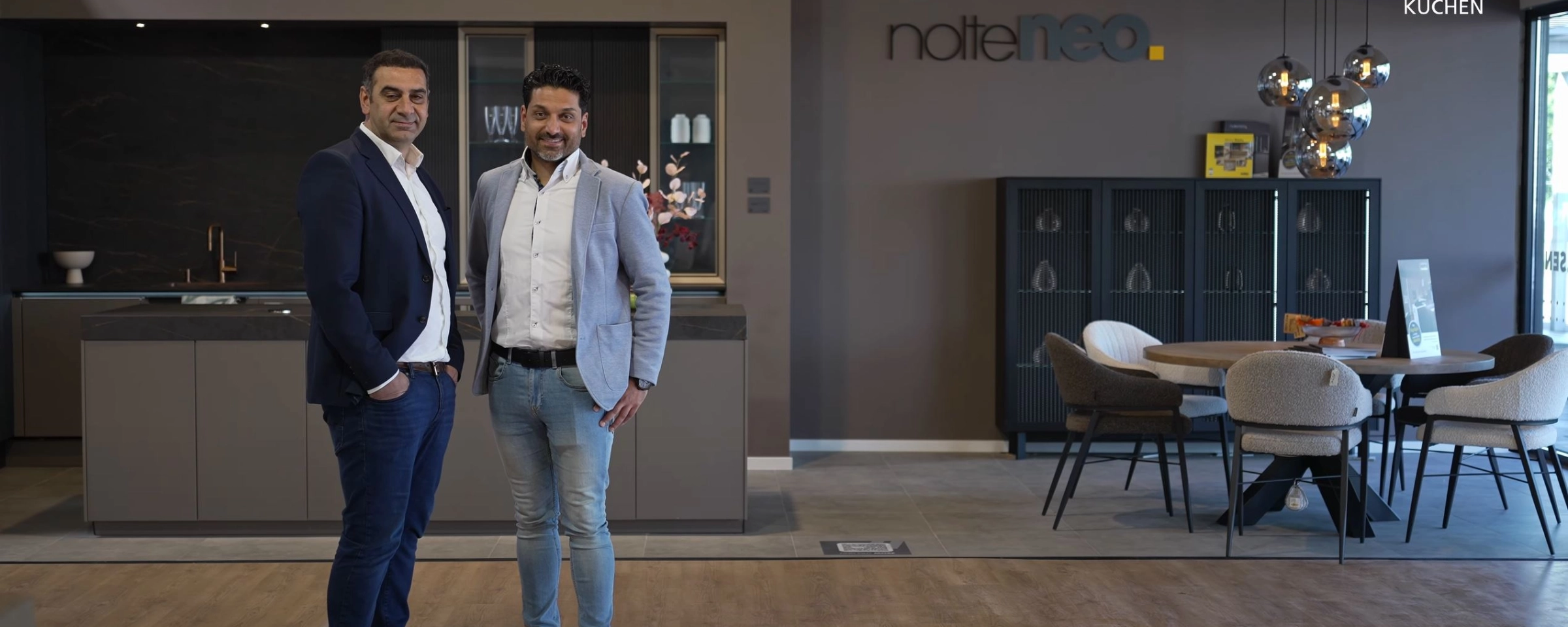 Deux hommes se tiennent dans une cuisine moderne conçue par NolteNeo de Nolte Kitchen.