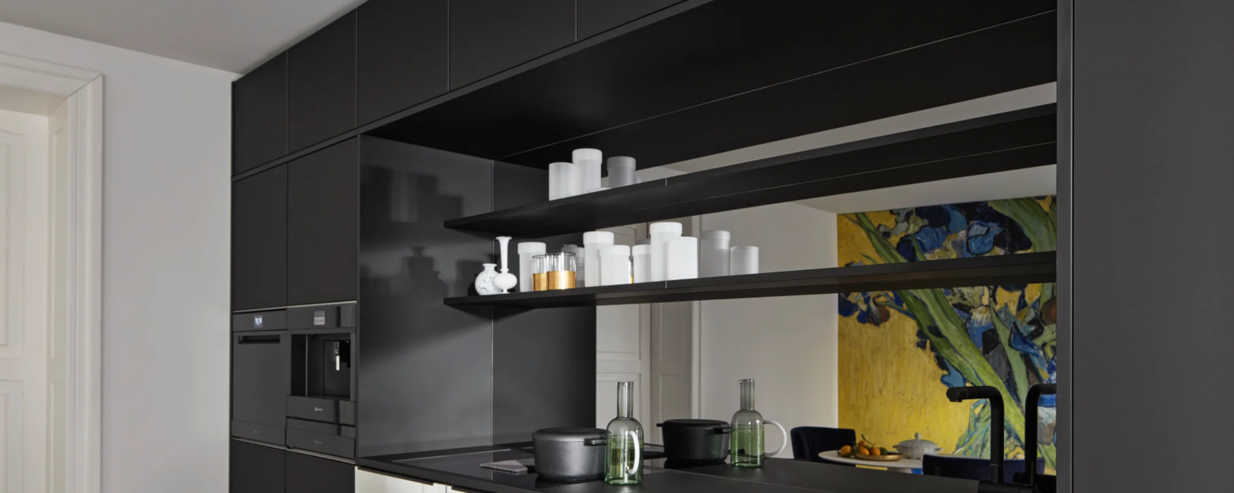 Een moderne, zwarte keuken met planken en apparaten, ontworpen door Nolte Kitchen.