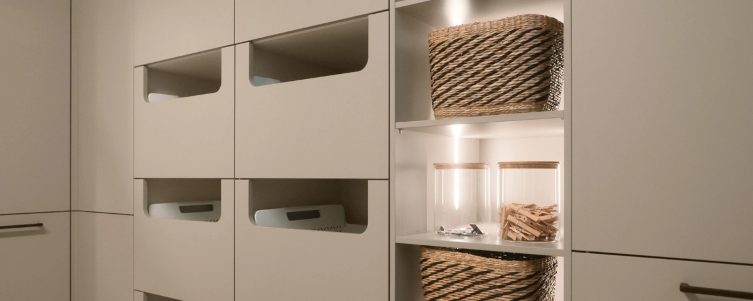 Een bijkeuken met open planken en laden vol manden, gepresenteerd door Nolte Bijkeukens.