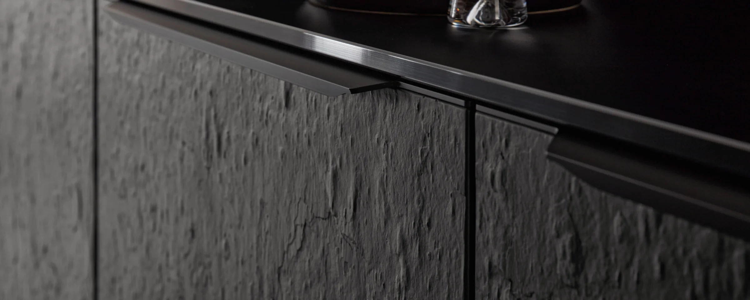 Cucina moderna con frontali scuri e strutturati e dettagli eleganti di Nolte Kitchen.