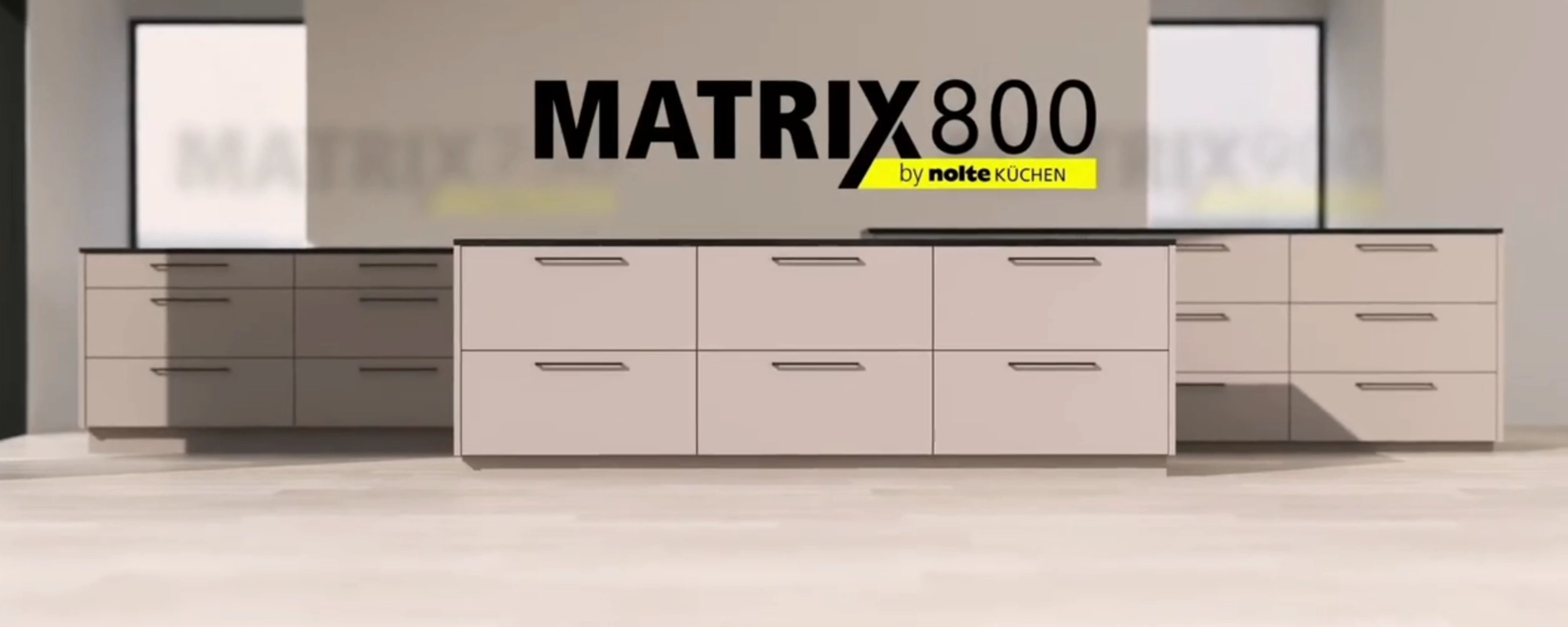 A modern kitchen with white cabinets and a black countertop by Nolte Kitchen.