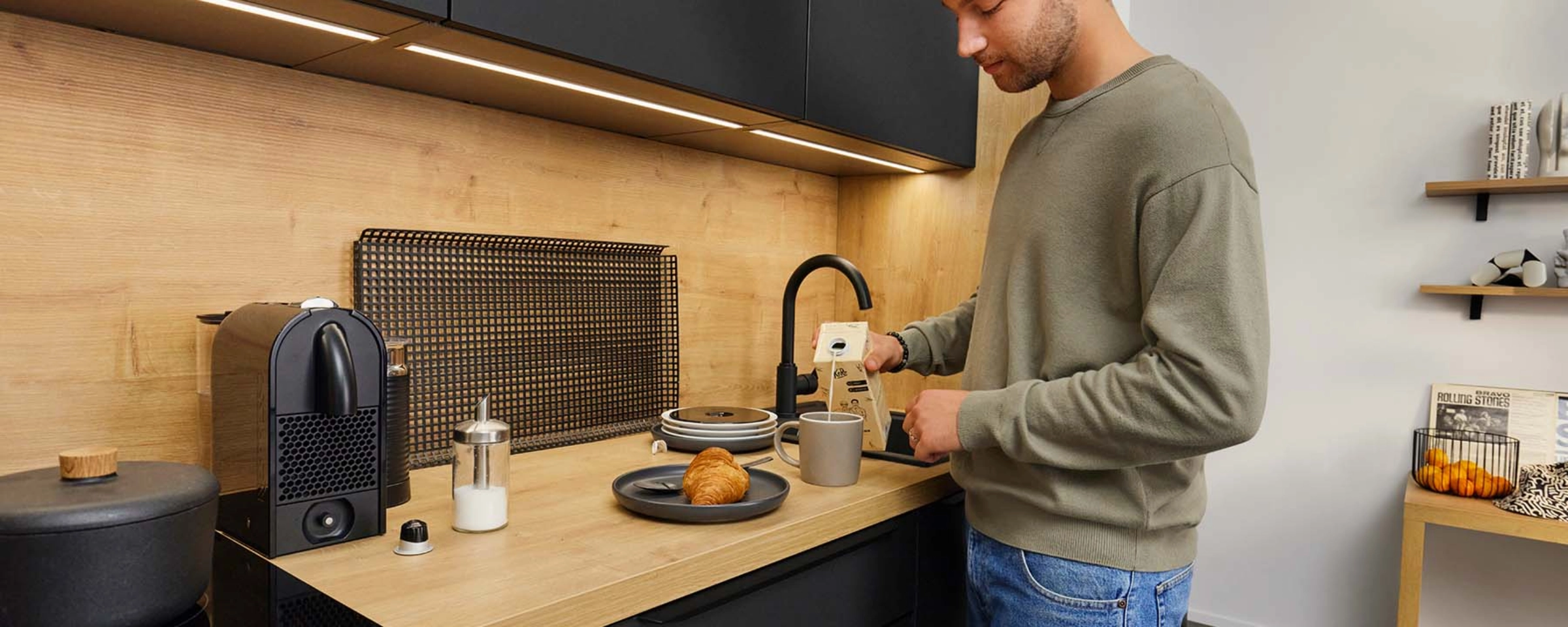 A man making coffee in a modern Nolte Kitchen kitchen.