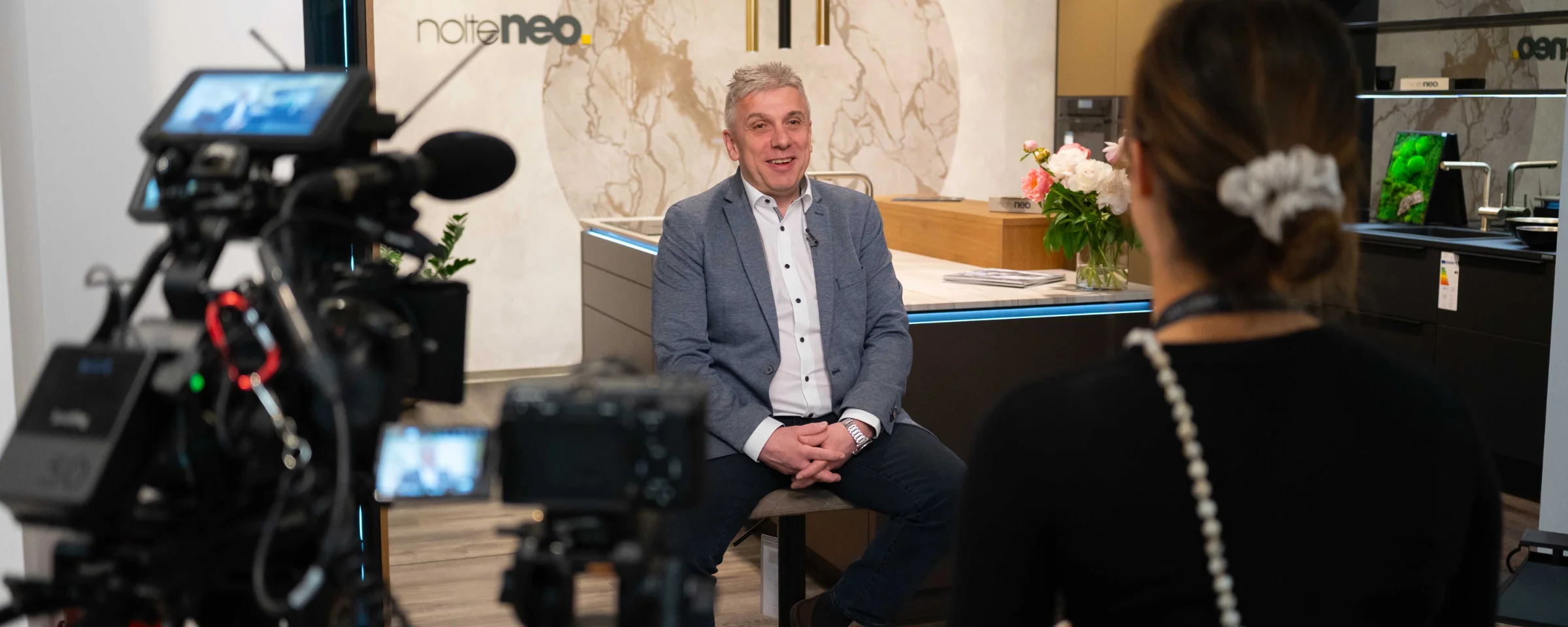 A person is being interviewed in a modern NolteNeo kitchen.
