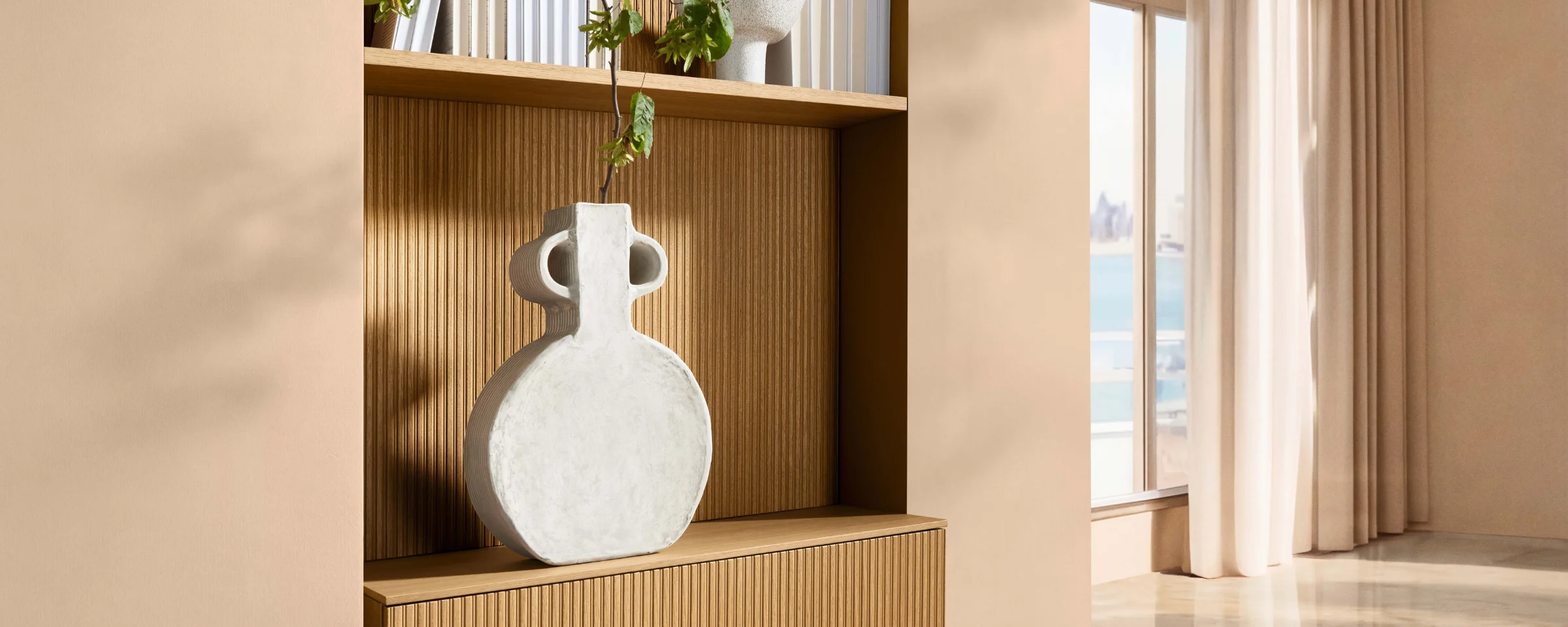 Ein stilvoller Raum mit Regal, Vase und Pflanzen. Nolte Living.