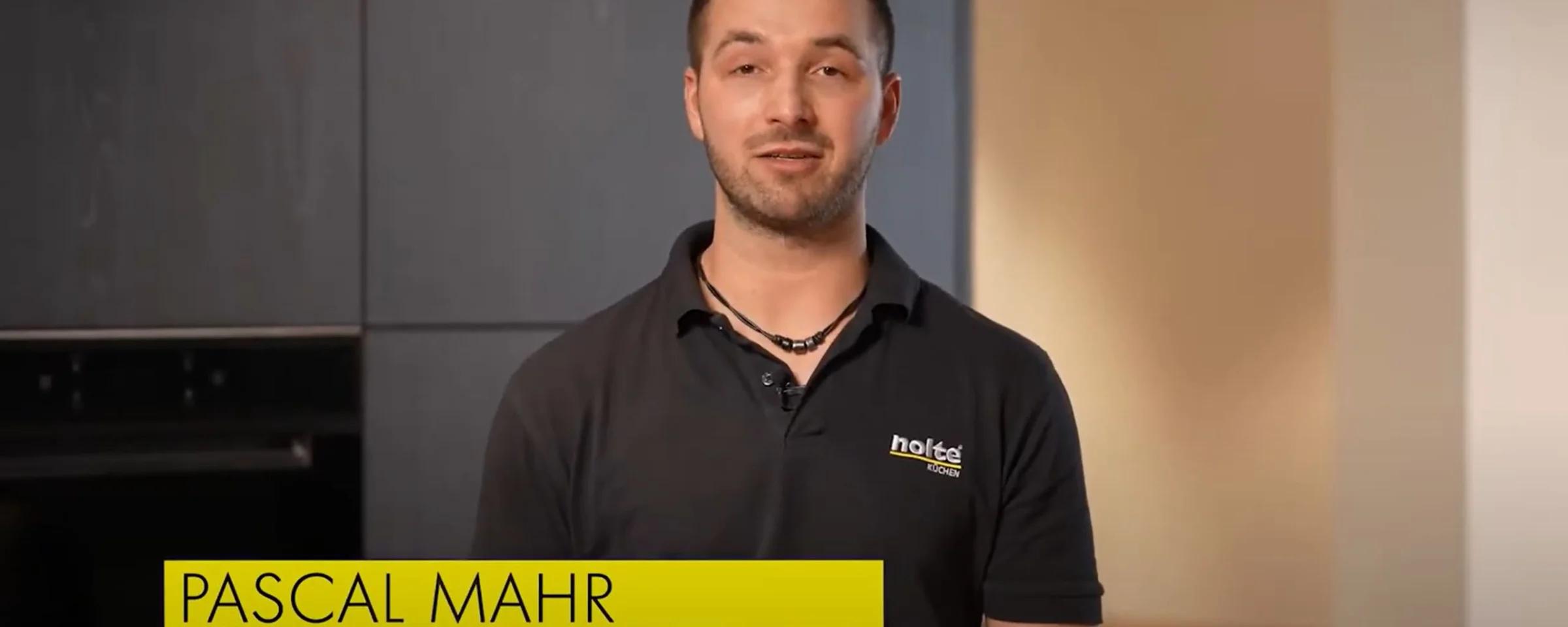 Ein Servicetechniker steht in einer modernen Küche von Nolte Küchen.