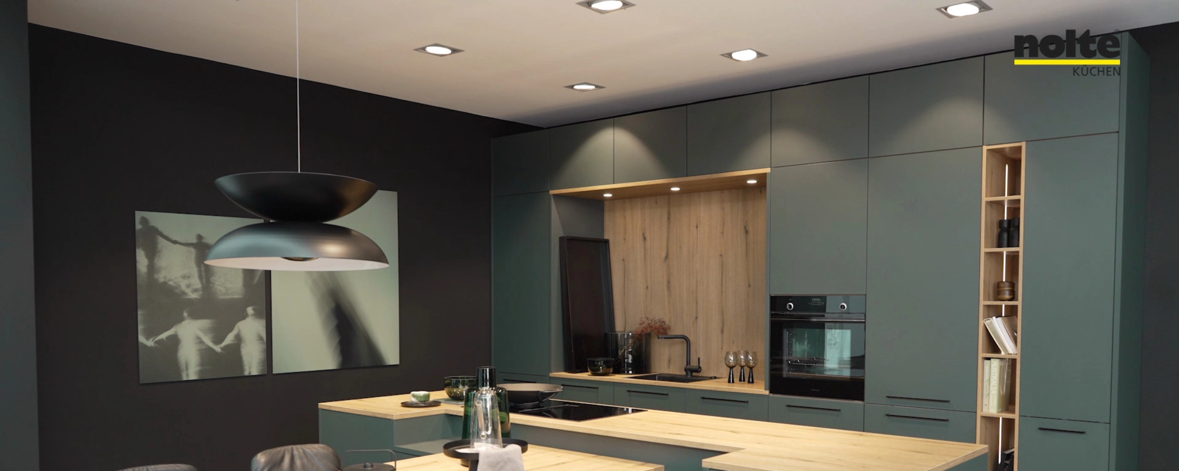 Une cuisine moderne avec des placards verts et des plans de travail en bois, aménagée par Nolte Kitchen.