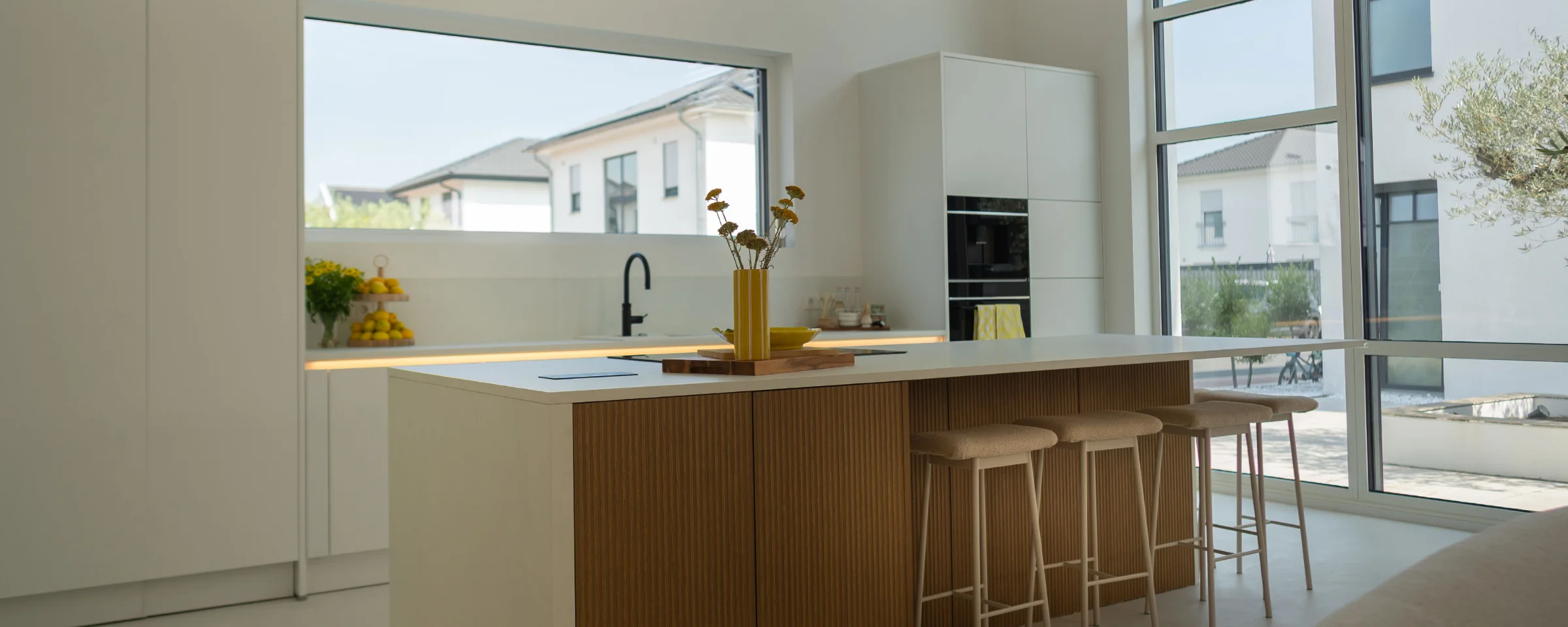 Une cuisine moderne avec grand îlot et tabourets de bar. Nolte Küchen.