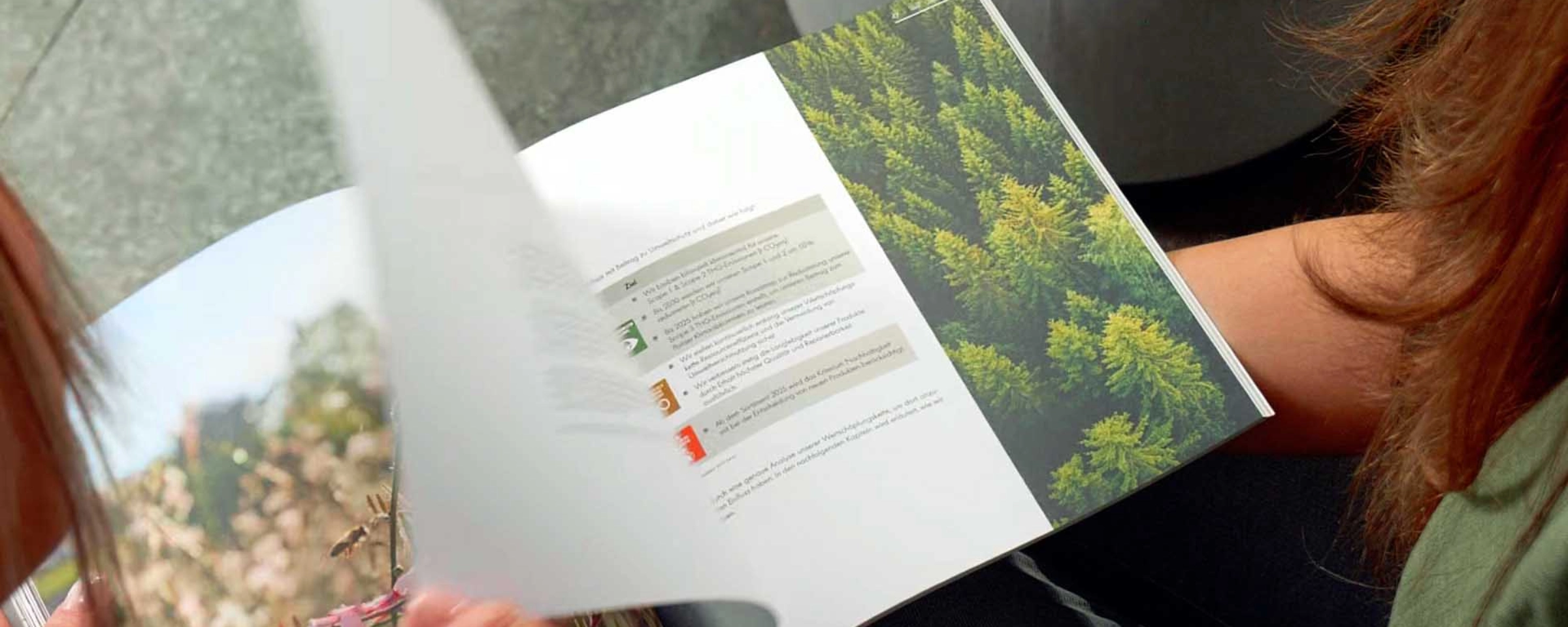 Une personne feuillette un catalogue d'images de nature. Nolte Kitchen.