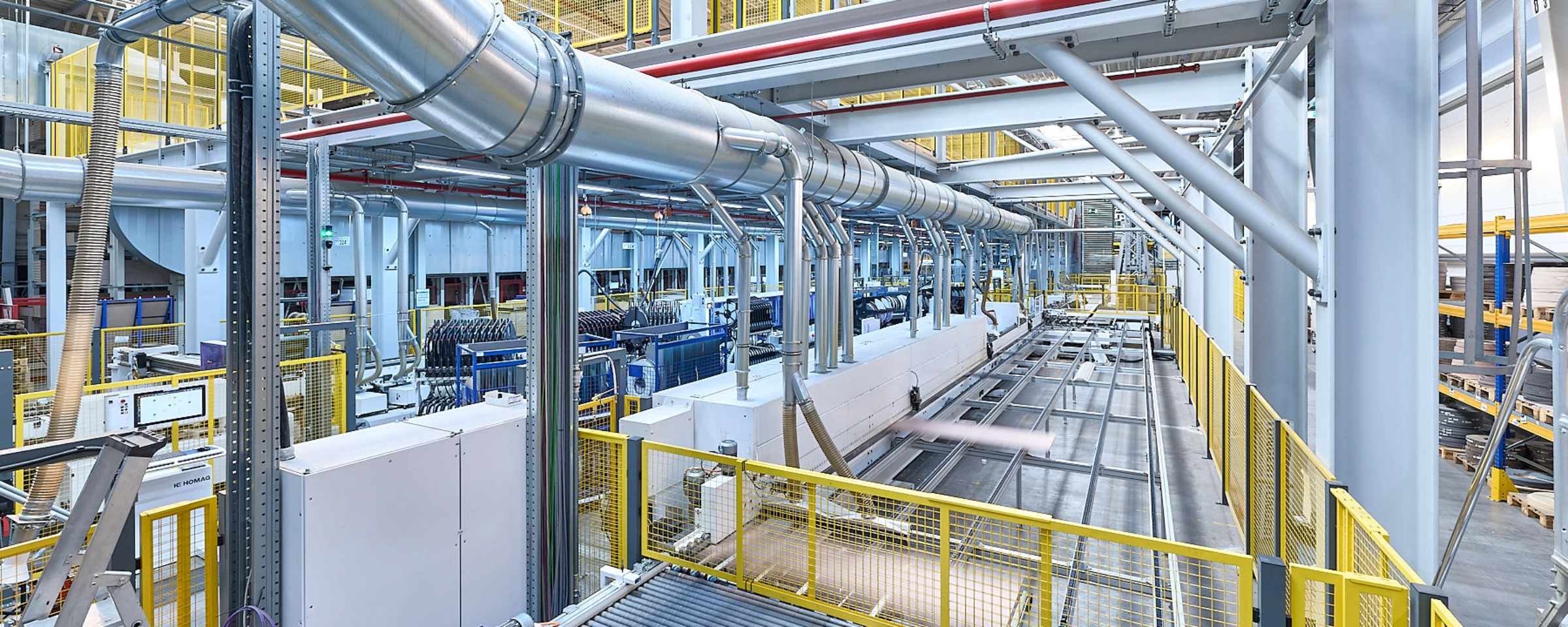 Eine moderne Produktionsanlage mit Metallstrukturen und Förderbändern in einer industriellen Umgebung.
