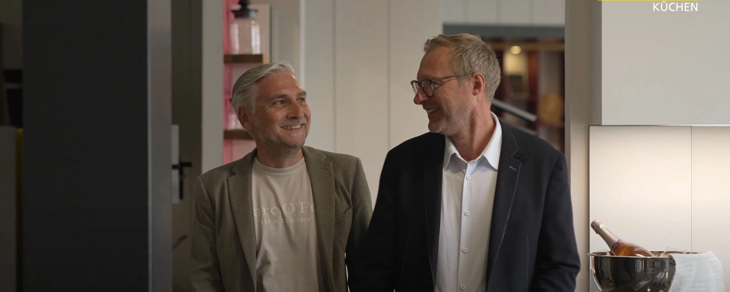 Dos hombres conversan en una cocina moderna de Nolte Cocina.