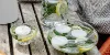 Candele al limone e alle erbe aromatiche fatte in casa, con candele galleggianti, come decorazione estiva naturale per la terrazza o il giardino.