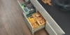 Cuisine moderne avec sol en bois, tiroirs ouverts avec provisions. Nolte Kitchen.