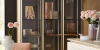 Une cuisine moderne avec vitrines en verre et façades en bois, décorée de fleurs et d'art, par Nolte Kitchen.