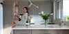 Una donna è seduta su un'isola cucina moderna con fiori, Nolte Kitchen.