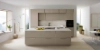 Cuisine moderne avec îlot, armoires claires et grandes fenêtres, conçue par Nolte Kitchen.