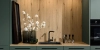 Une cuisine moderne avec des accents en bois et des armoires vertes de Nolte Kitchen.