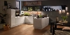 Cuisine moderne et élégante avec armoires blanches et sol en bois, conçue par Nolte Kitchen.