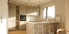A modern, bright kitchen with an island and barstools, designed by Nolte Kitchen.