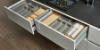 Tiroirs de cuisine ouverts avec compartiments à couverts et planches à découper dans une cuisine moderne de Nolte Kitchen.