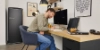 A man sits at a desk in a modern office featuring Nolte Living furniture.
