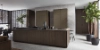 Exklusive Nolteneo cuisine avec la noble façade en bois neoLEAF en Noce Marone et l’élégante neoPURE en Metal Bronze. L’îlot de cuisine sans poignées présente un aspect bois véritable finement veiné, tandis que les armoires hautes en ton bronze métallique créent un contraste élégant. Le design séduit par des lignes claires, des matériaux de haute qualité et une impression d’espace luxueuse et ouverte.