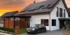 Maison moderne avec panneaux solaires sur le toit au coucher du soleil.