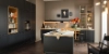 A modern kitchen with dark cabinets and a light countertop, designed by Nolte Kitchen.