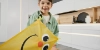 Un niño con un cometa amarillo sonríe en una cocina moderna que muestra Nolte Cocina.