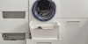 Une buanderie moderne avec machine à laver et rangement, conçue par Nolte Utility Rooms.