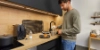 A man making coffee in a modern Nolte Kitchen kitchen.