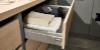 Un meuble à tiroirs ouvert avec des serviettes et des vêtements dans une buanderie de Nolte Utility Rooms.