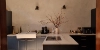 Cuisine moderne avec îlot et armoires sombres, éclairée par un lustre. Nolte Kitchen.