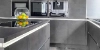 Cuisine moderne avec armoires grises et corbeille de fruits sur le plan de travail de Nolte Kitchen.