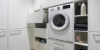 Buanderie moderne avec machine à laver et rangement, conçue par Nolte Utility Rooms.