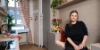 Une femme est assise dans une cuisine moderne avec des plantes, design de Nolte Kitchen.