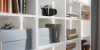 Une étagère avec des livres, un appareil photo et des boîtes; exemple de rangement élégant par Nolte Living.