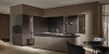 Élégante cuisine Nolte avec la façade exclusive neoLODGE en chêne noirci rainuré, combinée avec SOFT LACK en Magma softmatt. L’îlot de cuisine sans poignées avec plan de travail sombre rencontre des éléments vitrines haut de gamme et crée, en association avec les éléments bois structurés, une ambiance noble et conviviale dans un design moderne.