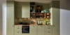 Cuisine Nolte élégante avec la façade SOFT LACK en Avocado softmatt. La ligne de cuisine sans poignées combine un vert doux avec un plan de travail en bois chaud et des étagères ouvertes. L’atmosphère conviviale est soulignée par des éléments décoratifs, des plantes et des matériaux naturels – une cuisine moderne avec des couleurs fraîches et des lignes épurées.