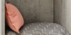 Un coussin gris à rayures blanches et un coussin rose sur une étagère. Nolte Living.
