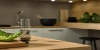 Une cuisine moderne avec surfaces en bois et salade sur la table, conçue par Nolte Kitchen.