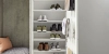Un meuble à chaussures ouvert avec diverses chaussures et un coin salon, partie de la collection Nolte Living.