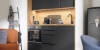 A modern kitchen with black cabinets and wood accents by Nolte Kitchen.