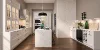 American farmhouse kitchen with kitchen island, white framed cabinet fronts, glass display cabinets and an open-plan living concept.