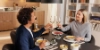 Un couple dîne dans une cuisine moderne et trinque avec des verres de vin. Nolte Kitchen.