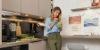 Una donna beve un frullato in una cucina moderna di Nolte Kitchen.