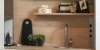 Une cuisine moderne avec étagères en bois et évier, décorée de plantes et accessoires. Nolte Kitchen.