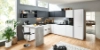 Cuisine Nolte moderne en forme de L et bar avec façades FEEL en Arcticweiß softmatt et façades PLUS en Schwarz softmatt. Le design sans poignées est complété par un comptoir marquant en aspect béton. L'effet lumineux et ouvert de la pièce est soutenu par beaucoup de lumière naturelle et des matériaux naturels comme le parquet en bois et les plantes – un espace élégant et fonctionnel pour cuisiner et vivre.